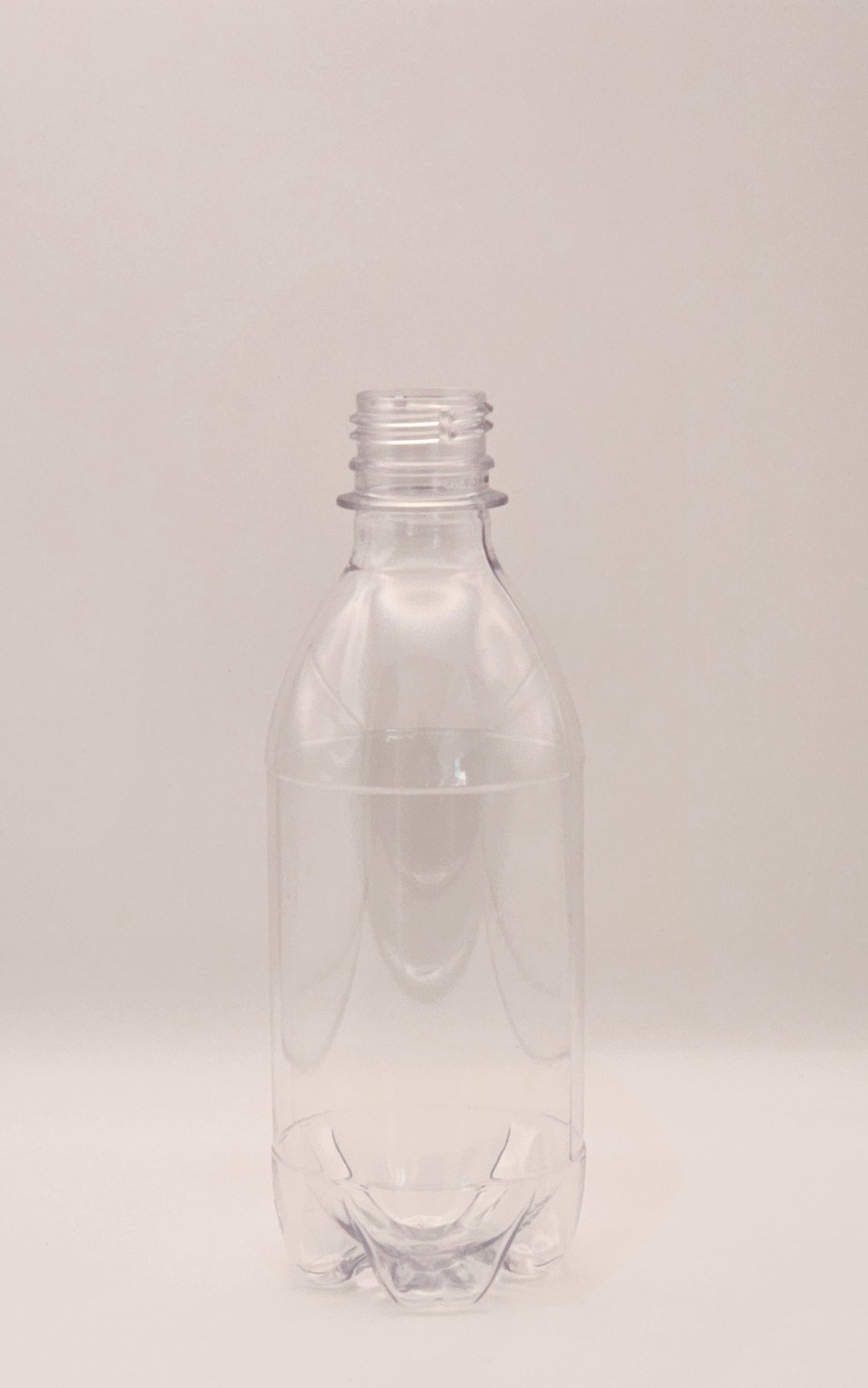 350ml clear CO2 carbo bottle with 28mm cap filled with pink lemonade on outdoor table – Croftpak NZ packaging