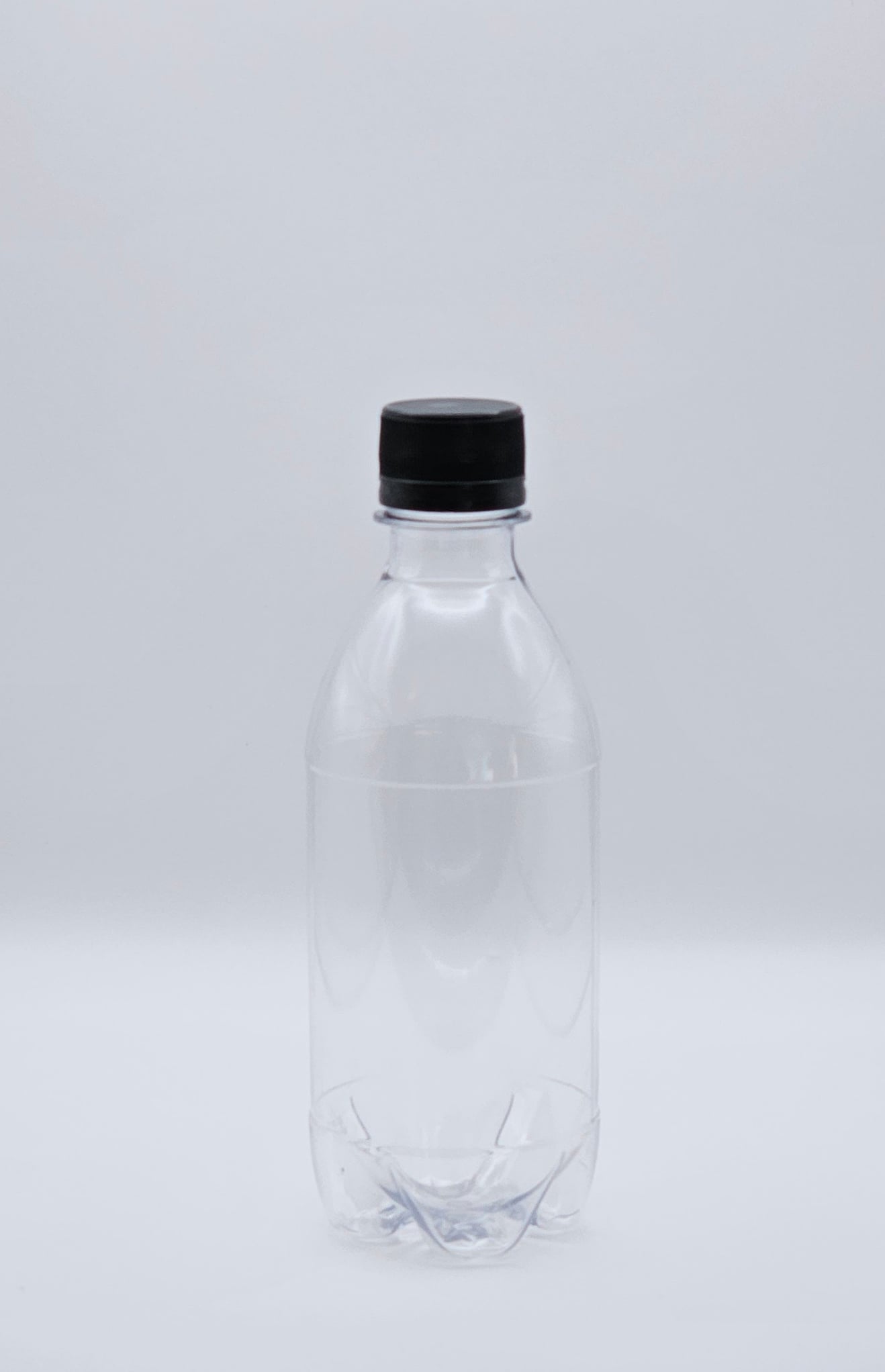 350ml clear CO2 carbo bottle with 28mm cap filled with pink lemonade on outdoor table – Croftpak NZ packaging